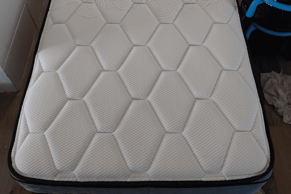 Freshly cleaned, spotless white mattress with a geometric pattern-